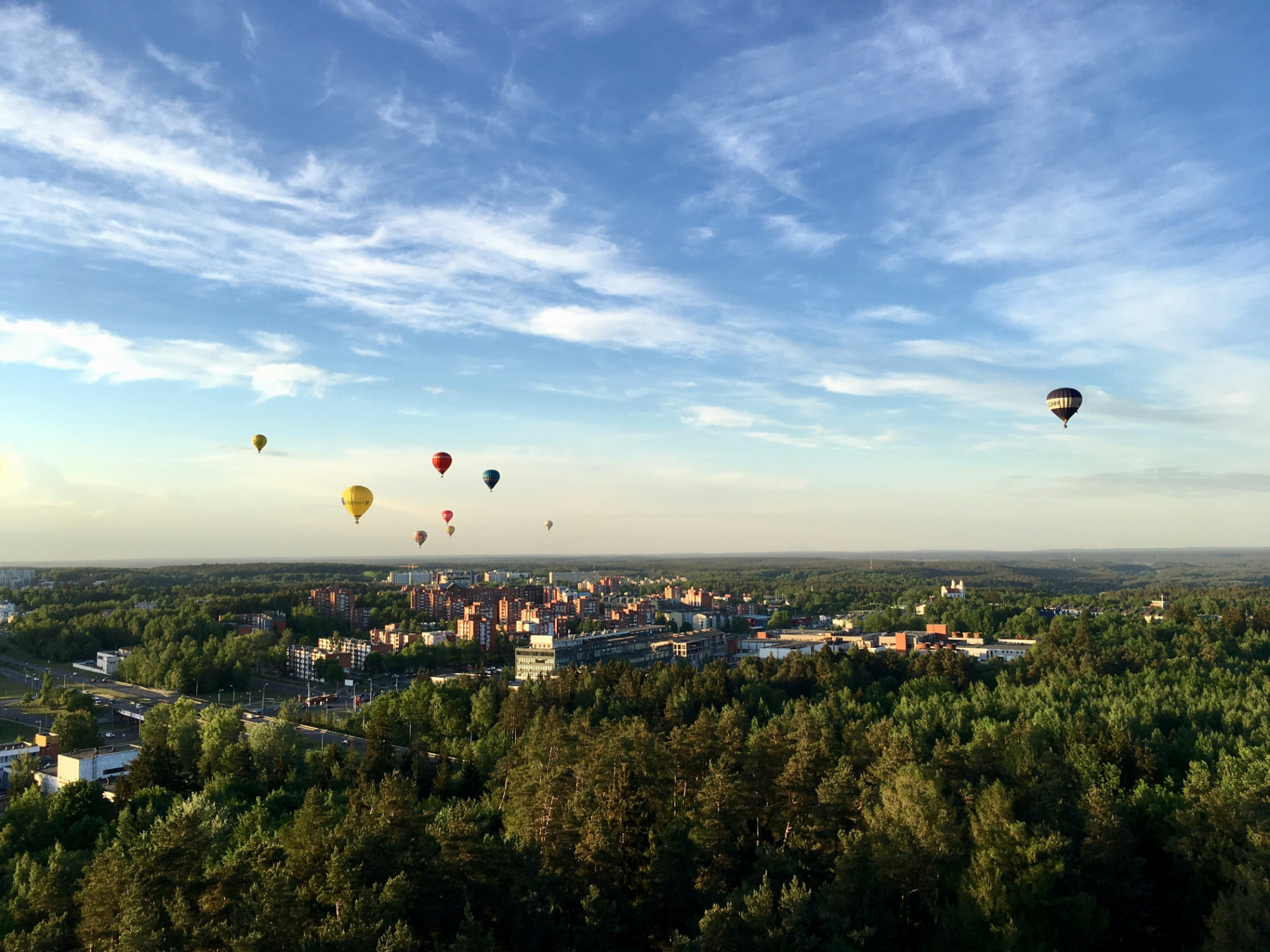 Hot air balloons drifting over Vilnius on a summer evening